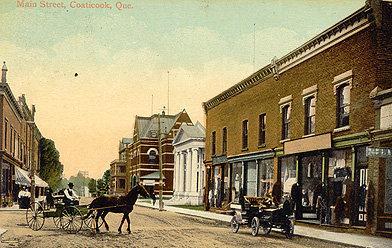 View of a commercial part of town. Shown in this postcard, among other things, the bank Easthern Townships and the post office does not have the tower and its clock.